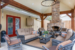 Continental back patio with dark stain columns and wood beams custom built stone outdoor fireplace