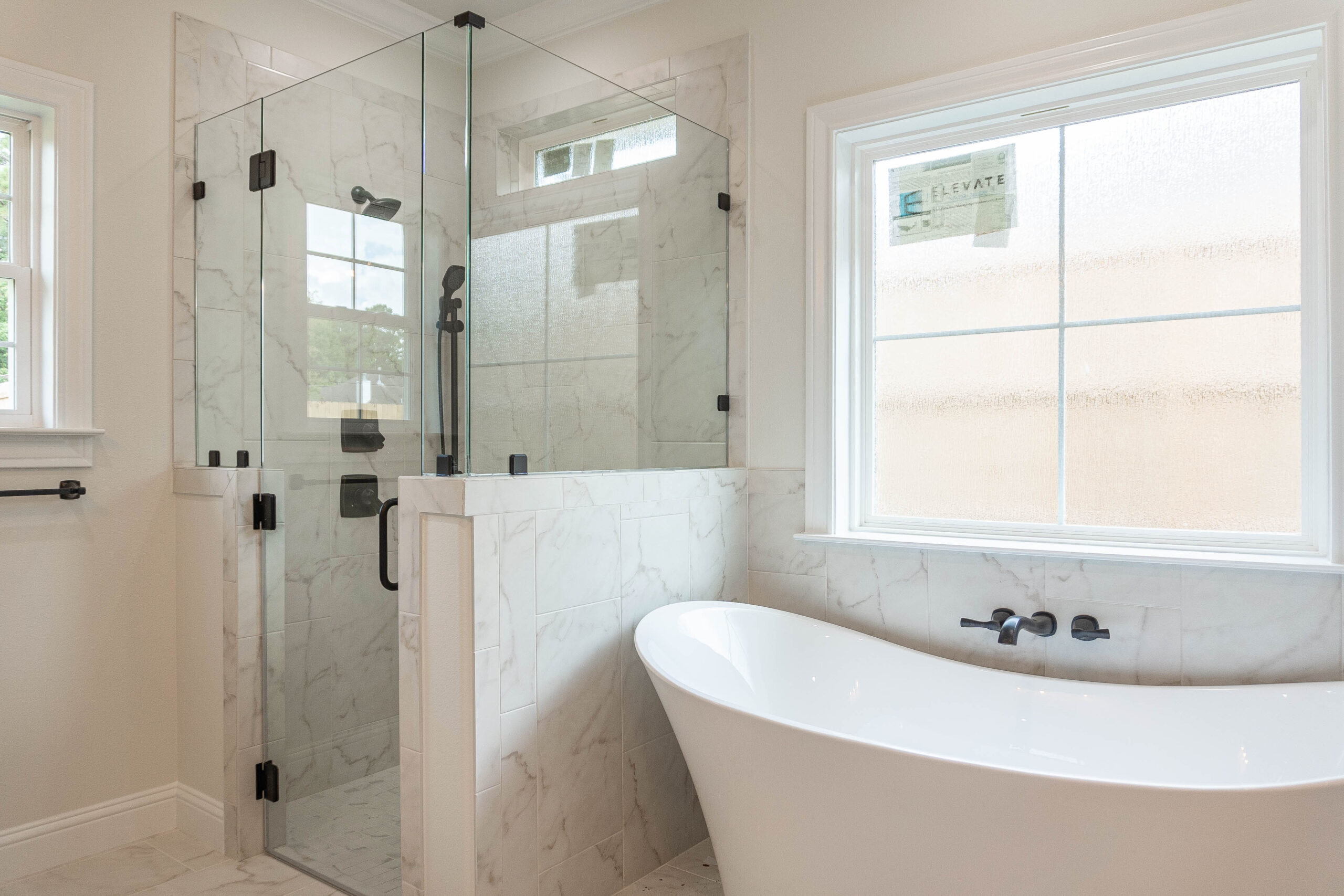 330 Hidden Grove master bathroom white tile flooring green shaker style cabinets free standing tub half tile wall glass shower