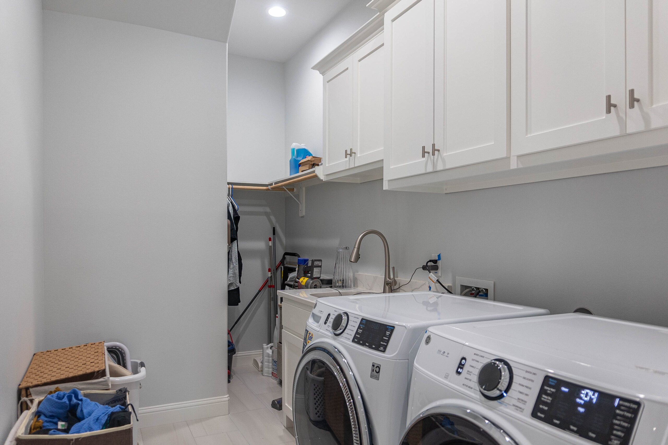 Esplanade Laundry white tile floor grey walls white shaker cabinets with silver hardware