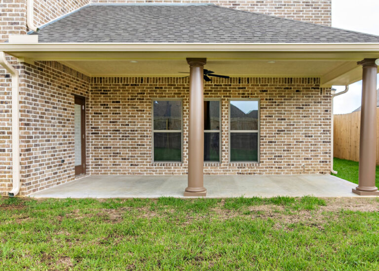 240 Riverstone Court two story home back patio with tan brown brick fluted columns