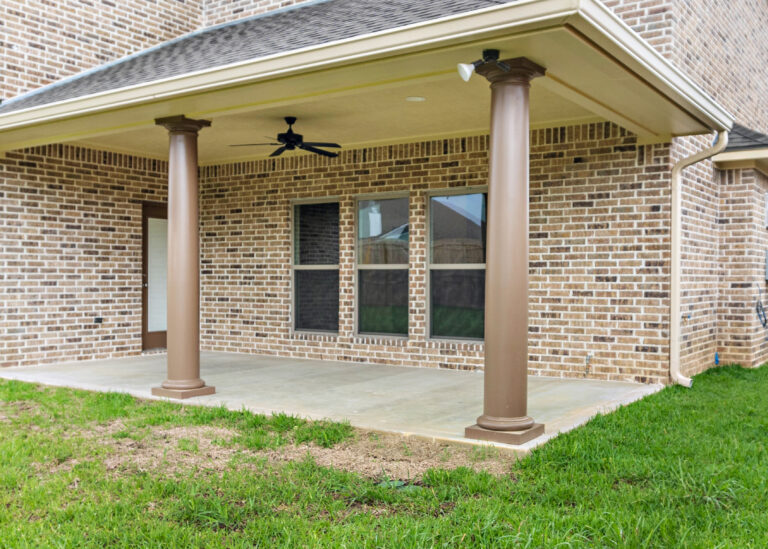 240 Riverstone Court two story home back patio with tan brown brick and fluted round columns concrete porch